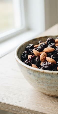 A ceramic bowl of dried fruit and nuts styled as a host gift